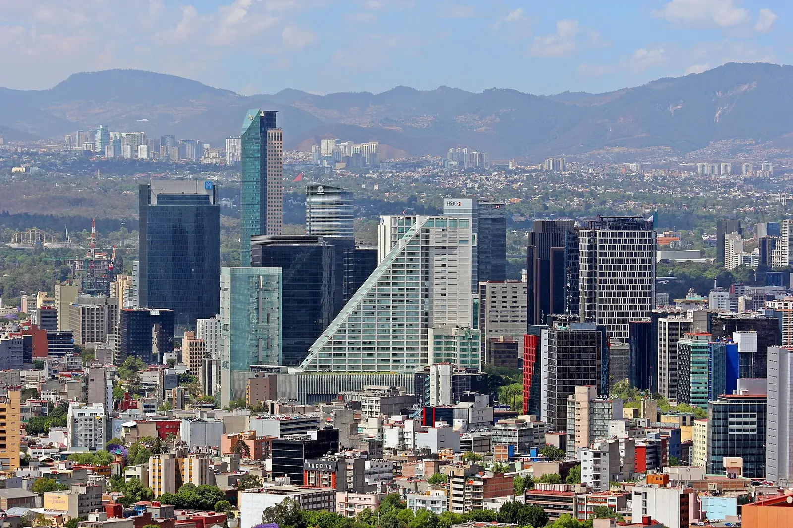 Towers along Paseo de la Reforma in Mexico City with mountains behind